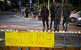 Candles lit at the site where Ethiopian-Israeli Yehuda Biadga was shot and killed as a he ran at a policeman while allegedly waving a knife, seen here in Bat Yam on January 20, 2019. The poster reads "Yehuda Biadga was murdered here." (Flash90)