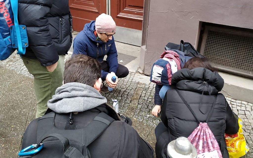 Volunteers clean stolpersteine in Berlin's Kreuzberg neighborhood on international Holocaust Remembrance Day, January 27, 2019. (Yaakov Schwartz/Times of Israel)