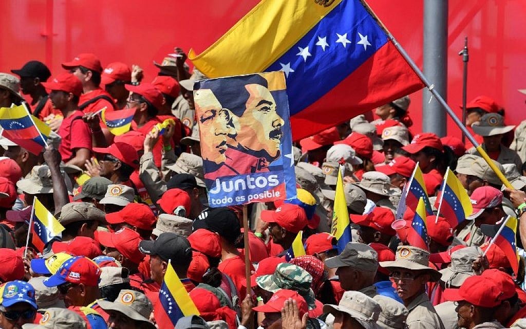 Supporters of Venezuelan President Nicolas Maduro gather to mark the 20th anniversary of the rise of power of the late Hugo Chavez, the leftist firebrand who installed a socialist government, in Caracas on February 2, 2019. - Protesters flowed into the streets of Caracas Saturday, with flags and placards, many to support opposition leader Juan Guaido's calls for democratic elections and others to back embattled President Nicolas Maduro. (Photo by Yuri CORTEZ / AFP)