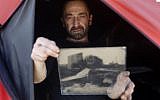 Edward Kaprov, an Israeli photographer, holds one of his images on a glass plate in his field darkroom, near Kibbutz Kissufim, overlooking the northern Gaza border, on February 5, 2019. (Menahem Kahana/AFP)