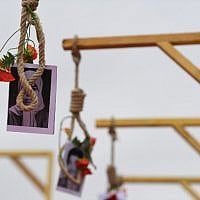 A picture shows a portrait of an Iranian opponent and flowers placed on a gallows, during a demonstration of the exiled Iranian opposition to protest against the Iranian government on February 8, 2019 in Paris. (Alain JOCARD / AFP)