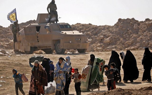 Civilians fleeing the battered Islamic State-held holdout of Baghouz in the eastern Syrian province of Deir Ezzor walk past an armored vehicle and into a nearby area held by the Syrian Democratic Forces (SDF) on February 12, 2019. Delil souleiman/AFP) Civilians fleeing the battered Islamic State-held holdout of Baghouz in the eastern Syrian province of Deir Ezzor walk past an armored vehicle and into a nearby area held by the Syrian Democratic Forces (SDF) on February 12, 2019. Delil souleiman/AFP)
