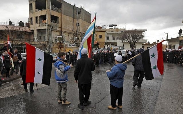 Young Druze residents of the Golan Heights hold the Syrian and the Druze flags during a rally in the village of Majdal Shams in the Golan Heights on February 14, 2019 (JALAA MAREY / AFP)