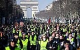 People walk down the Champs Elysees avenue in Paris on February 16, 2019 during the 14th consecutive week of 'yellow vest' protests. (Eric Feferberg/AFP)