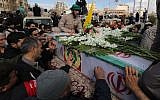 Illustrative: Iranian mourners gather around the coffins of Revolutionary Guards members who were killed in a suicide attack, during their funeral in southeastern city of Isfahan on February 16, 2019. (Atta Kenare/AFP)