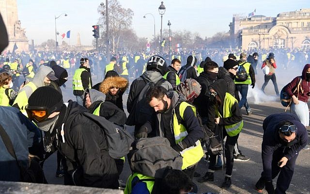 Protesters take part in a demonstration amid tear gas smoke on February 16, 2019 in Paris. (ERIC FEFERBERG / AFP) Protesters take part in a demonstration amid tear gas smoke on February 16, 2019 in Paris. (ERIC FEFERBERG / AFP)