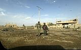 Fighters of the US-backed Kurdish-Arab coalition of the Syrian Democratic Forces (SDF) walk past destroyed buildings during an operation to expel Islamic State group (IS) jihadists from their last bastion, in Baghouz in eastern Syria on February 16, 2019. (Delil souleiman / AFP)