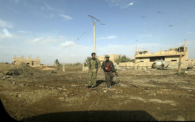 Fighters of the US-backed Kurdish-Arab coalition of the Syrian Democratic Forces (SDF) walk past destroyed buildings during an operation to expel Islamic State group (IS) jihadists from their last bastion, in Baghouz in eastern Syria on February 16, 2019. (Delil souleiman / AFP) Fighters of the US-backed Kurdish-Arab coalition of the Syrian Democratic Forces (SDF) walk past destroyed buildings during an operation to expel Islamic State group (IS) jihadists from their last bastion, in Baghouz in eastern Syria on February 16, 2019. (Delil souleiman / AFP)