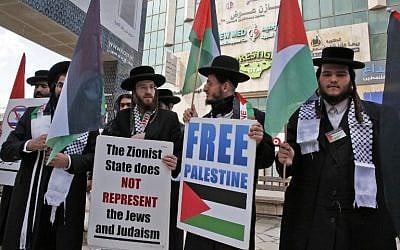 Illustrative: Ultra-Orthodox Jewish men belonging to Neturei Karta, a small faction of anti-Zionist ultra-Orthodox Jews who oppose Israel's existence, hold placards during an annual demonstration in memory of the 1994 massacre at the Cave of the Patriarchs, in the West Bank city of Hebron, February 22, 2019. (HAZEM BADER / AFP)