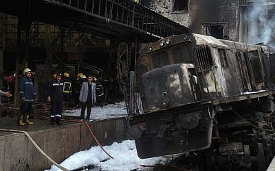 Fire fighters and onlookers gather at the scene of a fiery train crash at the Egyptian capital Cairo's main railway station on February 27, 2019 (Hussein Talal / AFP)