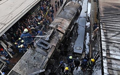 Firefighters and onlookers gather at the scene of a fiery train crash at the Egyptian capital Cairo's main railway station on February 27, 2019. (Stringer/AFP)