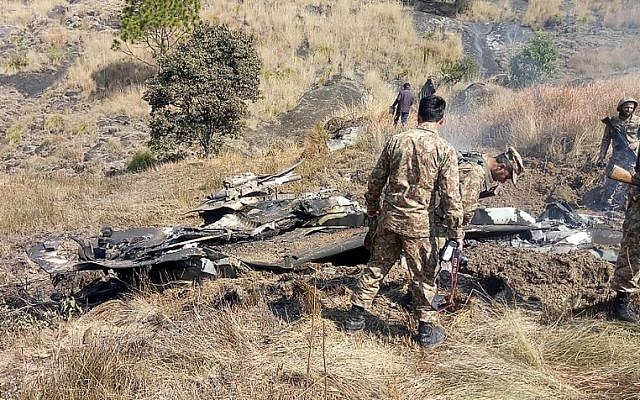 Pakistani soldiers stand next to what Pakistan says is the wreckage of an Indian fighter jet shot down in Pakistan-controlled Kashmir in the Somani area in Bhimbar district near the Line of Control on February 27, 2019. (STR/AFP) Pakistani soldiers stand next to what Pakistan says is the wreckage of an Indian fighter jet shot down in Pakistan-controlled Kashmir in the Somani area in Bhimbar district near the Line of Control on February 27, 2019. (STR/AFP)