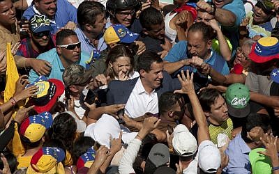 Venezuelan opposition leader Juan Guaido, center, who has declared himself the interim president of Venezuela, greets supporters as he arrives at a demonstration demanding the resignation of President Nicolas Maduro, in Caracas, Venezuela, on February 2, 2019. (AP/Juan Carlos Hernandez)