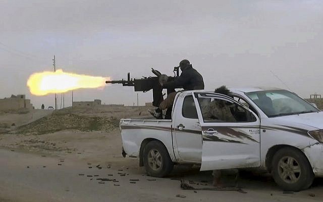 This frame grab from video posted online January 18, 2019, by supporters of the Islamic State group, purports to show a gun-mounted Islamic State group vehicle firing at members of the US-backed Syrian Democratic Forces, in the eastern Syrian province of Deir el-Zour, Syria. (Militant Photo via AP) This frame grab from video posted online January 18, 2019, by supporters of the Islamic State group, purports to show a gun-mounted Islamic State group vehicle firing at members of the US-backed Syrian Democratic Forces, in the eastern Syrian province of Deir el-Zour, Syria. (Militant Photo via AP)