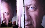 People walk by posters of ex-IDF chief Benny Gantz before the official launch of his election campaign for the April 2019 elections, in Tel Aviv on January 29, 2019. (AP Photo/Oded Balilty)