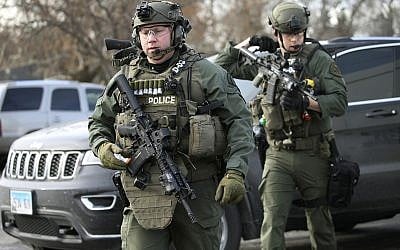 Police officers armed with rifles gather at the scene where an active shooter was reported in Aurora, Illinois on Friday, Feb. 15, 2019. (Antonio Perez/Chicago Tribune via AP)