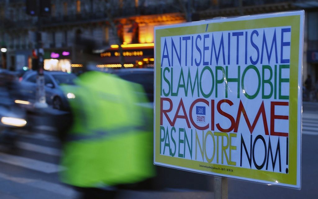 A poster reading 'Anti-Semitism, Islamophobia, Racism, Not in Our Name" during a gathering decrying anti-Semitism at Place de la Republique in Paris, February 18, 2019 amid an upsurge in anti-Semitism in France. (AP/Francois Mori)