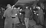 A crowd of demonstrators outside New York's Madison Square Garden as they seize a uniformed member of the German American Bund who had emerged from a Bund rally and attempted to enter a taxi, February 20, 1939. (AP Photo, File)