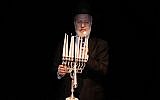 In this photo from December 5, 2018, distributed by AMIA, Argentina's Chief Rabbi Gabriel Davidovich holds a menorah at the AMIA Jewish community center in Buenos Aires. (AMIA Jewish community center via AP)