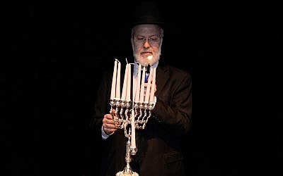 In this photo from December 5, 2018, distributed by AMIA, Argentina's Chief Rabbi Gabriel Davidovich holds a menorah at the AMIA Jewish community center in Buenos Aires. (AMIA Jewish community center via AP)