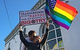 Nick Rondoletto, left, and Doug Thorogood, a couple from San Francisco, wave a rainbow flag and hold a sign against a ban of transgendered people in the military at a protest in the Castro District on July 26, 2017, in San Francisco. (AP Photo/Olga R. Rodriguez/File)