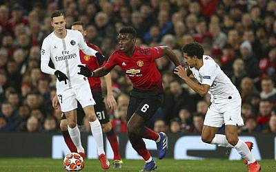 Manchester United's Paul Pogba, centre, vies for the ball with Paris Saint Germain's Marcos Marquinhos, right, during the Champions League round of 16 soccer match between Manchester United and Paris Saint Germain at Old Trafford stadium in Manchester, England, Tuesday, Feb. 12,2019.(AP Photo/Dave Thompson)