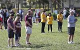 People at Trails End Park pause for a moment of silence in honor of the 17 that were killed during the Marjory Stoneman Douglas High School shooting last year, Thursday, Feb. 14, 2019, in Parkland, Fla. (AP/Wilfredo Lee)