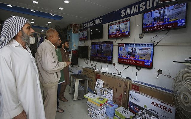 Pakistanis watch news bulletins on television in Karachi, Pakistan, February 27, 2019. (Fareed Khan/AP)