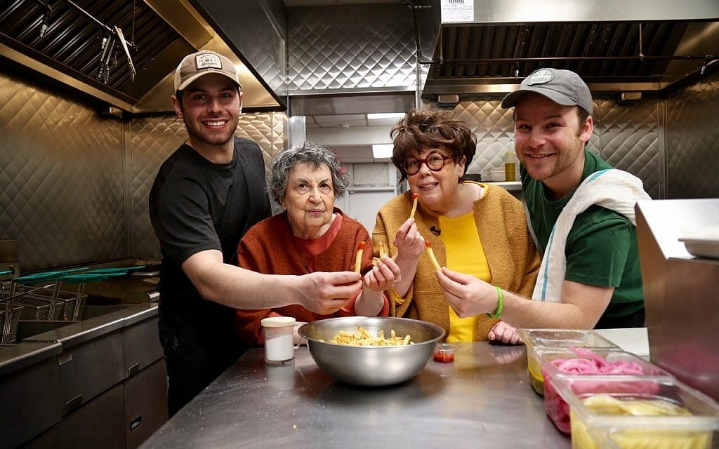 Sheila (center left) and Marilynn Brass learn to make cheeseburgers at Mainely Burgers in Cambridge, Massachusetts from Jack Barber (far left) and Max Barber (right). (Bruce Seidel)