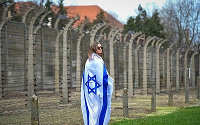 A woman wrapped in an Israeli flag at the March of the Living at the Auschwitz-Birkenau camp site in Poland, April 11, 2018 (Yossi Zeliger/Flash90)