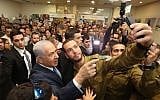 Prime Minister Benjamin Netanyahu takes a selfie with a soldier during an event for lone soldiers in Tel Aviv, on January 24, 2019. (Marc Israel Sellem/Pool/Flash90)
