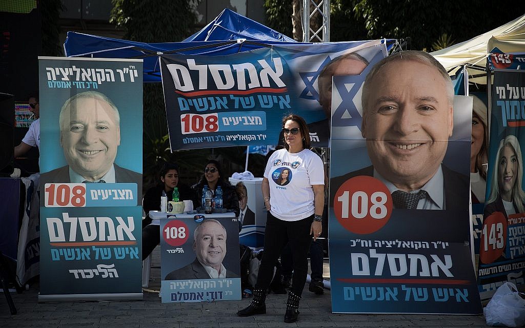 Likud supporters campaign for party member David Amsalem  outside Tel Aviv Likud polling station on February 5, 2019 (Hadas Parush/Flash90)