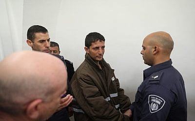 Police escort Arafat Irfaiya , charged with the murder of 19-year-old Ori Ansbacher, at the Jerusalem Magistrate's court, on February 11, 2019. (Yonatan Sindel/Flash90)