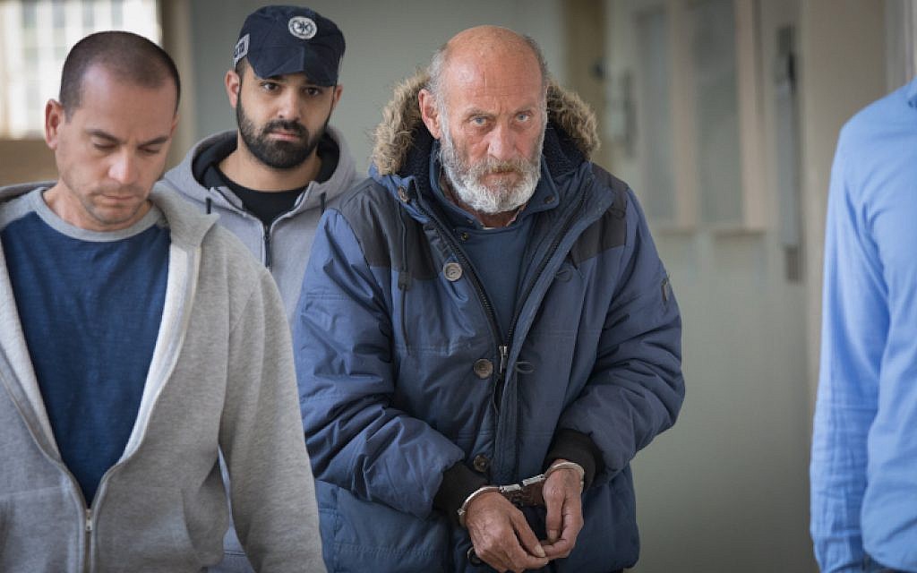 Valery Sakovich, suspect in the murder case of a young woman in 1993, escorted by police to a hearing at Jerusalem Magistrate's Court on February 6, 2019. (Noam Revkin Fenton/Flash90)