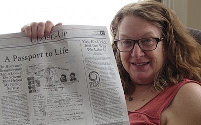 Heidi Fishman holding up an op-ed she wrote about her family’s rescue from the Holocaust using a Paraguayan passport. (Courtesy of Fishman via JTA)