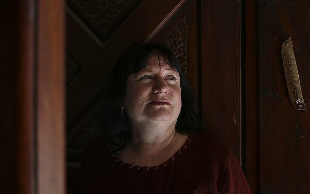 Riki Eyal stands in front of the door of her home in Arad (Johanna Chisholm/Times of Israel)