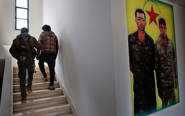 A Kurdish prison security guard, left, escorts a 19-year-old former fighter of the Islamic State group, into the courtroom of a Kurdish-run terrorism court, in Qamishli, north Syria, April 3, 2018. (AP Photo/Hussein Malla) A Kurdish prison security guard, left, escorts a 19-year-old former fighter of the Islamic State group, into the courtroom of a Kurdish-run terrorism court, in Qamishli, north Syria, April 3, 2018. (AP Photo/Hussein Malla)