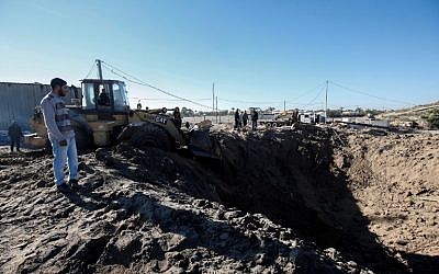 Palestinian men clear the rubble from an airstrike at a site the Israeli military said was tied to the Hamas terror group, near Khan Yunis in the southern Gaza Strip on March 9, 2019. (Said Khatib/AFP)