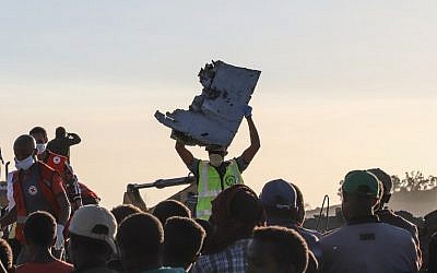 A man carries a piece of debris on his head at the crash site of a Nairobi-bound Ethiopian Airlines flight near Bishoftu, a town some 60 kilometers (37 miles) southeast of Addis Ababa, Ethiopia, on March 10, 2019. (Michael TEWELDE / AFP)