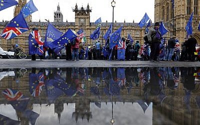 Anti-Brexit supporters wave flags as they demonstrate outside the Houses of Parliament in London on March 12, 2019. (Tolga Akmen/AFP)