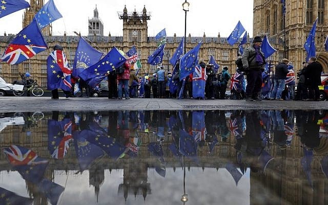 Anti-Brexit supporters wave flags as they demonstrate outside the Houses of Parliament in London on March 12, 2019. (Tolga Akmen/AFP) Anti-Brexit supporters wave flags as they demonstrate outside the Houses of Parliament in London on March 12, 2019. (Tolga Akmen/AFP)