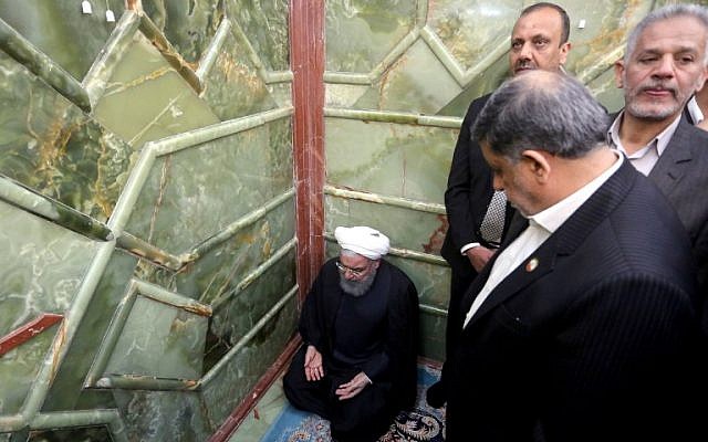 Iranian President Hassan Rouhani prays at the tomb of Imam Ali shrine in the Iraqi holy city of Najaf on March 13, 2019. (Haidar Hamdani/AFP)