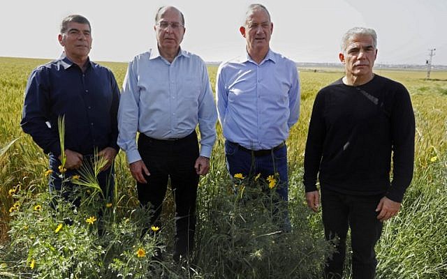Left to right: Blue and White party leaders Gabi Ashkenazi, Moshe Ya'alon, Benny Gantz and Yair Lapid stand in a wheat field at the border between Israel and the Gaza Strip, near the kibbutz of Kfar Aza, on March 13, 2019. (Menahem Kahana/AFP)