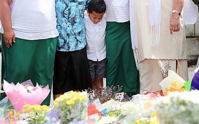 Residents pay their respects by placing flowers for the victims of the mosques attacks in Christchurch at the Masjid Umar mosque in Auckland on March 17, 2019.(Photo by MICHAEL BRADLEY / AFP)