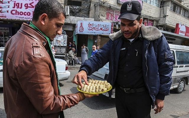 A Hamas supporter passes out sweets in the street in Rafah in the southern Gaza Strip on March 17, 2019, in celebration of a deadly shooting attack in the West Bank. (SAID KHATIB / AFP)
