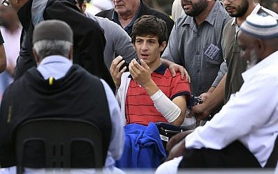 Zaid Mustafa (C, in wheelchair), who was wounded by an Australian white supremacist gunman, attends the funeral of his slain father Khalid Mustafa and brother Hamza Mustafa at the Memorial Park cemetery in Christchurch on March 20, 2019. Photo by WILLIAM WEST / AFP)