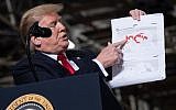 US President Donald Trump holds up a map detailing territory losses by the Islamic State in Syria as he speaks following a tour of the Lima Army Tank Plant at Joint Systems Manufacturing in Lima, Ohio, March 20, 2019. (SAUL LOEB / AFP)