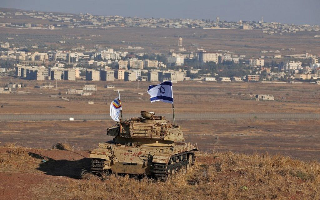 Photo taken on October 18, 2017 shows an Israeli flag fluttering above the wreckage of an Israeli tank sitting on a hill in the Golan Heights and overlooking the border with Syria. (Jalaa Marey/AFP) Photo taken on October 18, 2017 shows an Israeli flag fluttering above the wreckage of an Israeli tank sitting on a hill in the Golan Heights and overlooking the border with Syria. (Jalaa Marey/AFP)