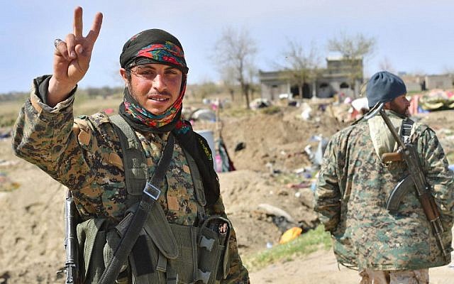 A picture taken on March 23, 2019, shows a fighter of the US-backed Kurdish-led Syrian Democratic Forces (SDF) flashing the V for victory sign in the fallen Islamic State group's last bastion in the eastern Syrian village of Baghuz after defeating the jihadist group. (GIUSEPPE CACACE / AFP) A picture taken on March 23, 2019, shows a fighter of the US-backed Kurdish-led Syrian Democratic Forces (SDF) flashing the V for victory sign in the fallen Islamic State group's last bastion in the eastern Syrian village of Baghuz after defeating the jihadist group. (GIUSEPPE CACACE / AFP)