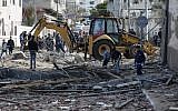 A picture taken on March 26, 2019, shows an excavator clearing debris next to the destroyed office of Hamas leader Ismail Haniyeh in Gaza City that was targeted the night before by an Israeli air raid. (Mahmud Hams/AFP)